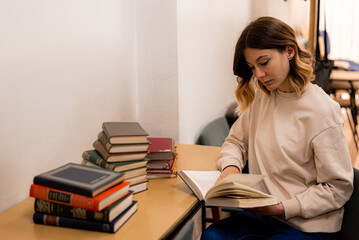 Wall Mural - Girl reads a book in a library