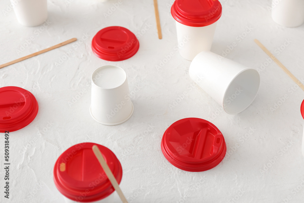 Takeaway paper cups and spoons on white background