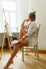 Young Woman Artist Painting On Canvas On The Easel