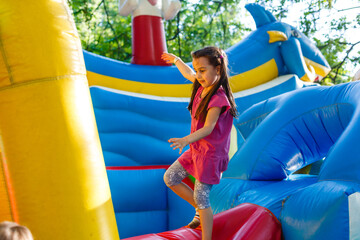 Wall Mural - A cheerful child plays in an inflatable castle