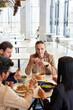 © Seventyfour - Vertical portrait of young businesswoman enjoying business lunch with colleagues in Asian food cafe