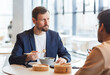 © Seventyfour - Portrait of bearded businessman enjoying Asian food during business lunch with colleague at shopping mall cafe