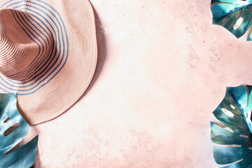 Wall Mural - Summer straw hat and monstera leaves on beige concrete background.Toned flat lay for tropical vacation concept.Copy space