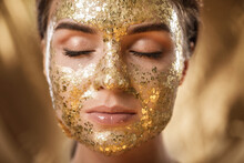 Beautiful Woman With Golden Shining Mask On Her Face For Skin Treatment