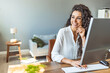 © Dragana Gordic - Successful businesswoman standing in creative office and looking at camera. Young latin woman entrepreneur in a coworking space smiling. Portrait of beautiful business woman