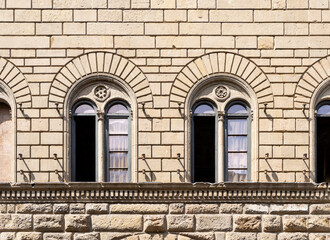 Wall Mural - Detail of the façade of Medici Riccardi palace designed by Renaissance architect Michelozzo with two mullioned windows, in Florence city center, Tuscany region, Italy