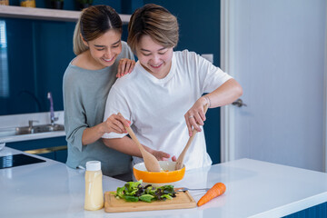 LGBTQ Asian lesbian homosexual Lesbian couples making healthy food together at home. LGBTQ, LGBTQ+, LGBT couple lovers in kitchen