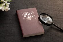 Top View Of The Holy Bible On The Desktop With Magnifiier. The Concept Of Bible Study And Search.