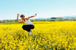 © carlesmiro - Portrait of young homosexual boy jumps in a yellow rapeseed field. Concept of a good mood and summer vacation.