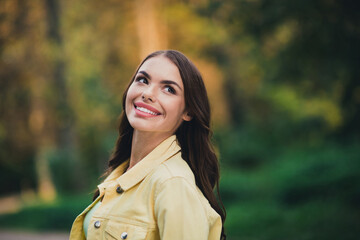 Wall Mural - Portrait of attractive dreamy cheerful brown-haired girl spending free time breathing oxygen good mood outdoors