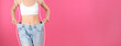 Closeup view of woman with slim body in oversized jeans on pink background, space for text. Banner design