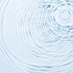 Wall Mural - The texture of water on a blue background in bright sunlight.