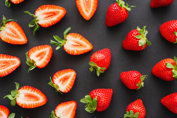 Wall Mural - Flat lay with natural red strawberries on black background.