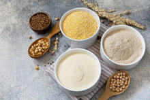 Food And Baking Gluten Free Ingredient. Cereals And Flours Coarse, Corn Flour, Buckwheat Flour, Chickpeas Flour Over Gray Stone Background. Copy Space.