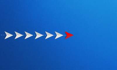 A group of white paper planes led by other red one in a straight path. leadership concept.