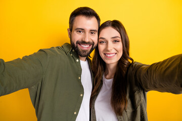 Poster - Closeup image of cheerful lovely couple make video vlog of her married life isolated on yellow color background