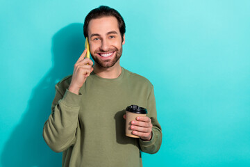 Canvas Print - Photo of young cheerful man speak cellphone enjoy latte espresso break isolated over teal color background