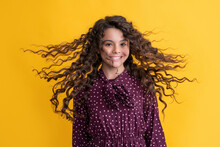 Smiling Girl With Long Brunette Curly Hair On Yellow Background