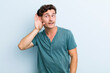 © kues1 - young handsome man smiling, looking curiously to the side, trying to listen to gossip or overhearing a secret