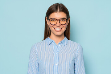 Wall Mural - Confident smiling female office worker in trendy glasses isolated over blue copy space background