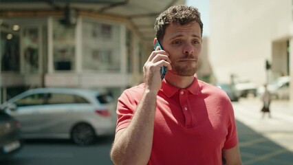 Wall Mural - Young hispanic man worried talking on the smartphone at street