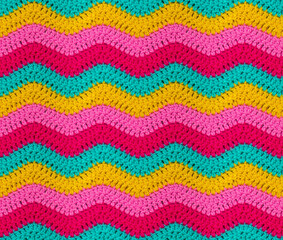 seamless knitted pattern in the form of zigzags is crocheted with bright multi-colored threads. acry