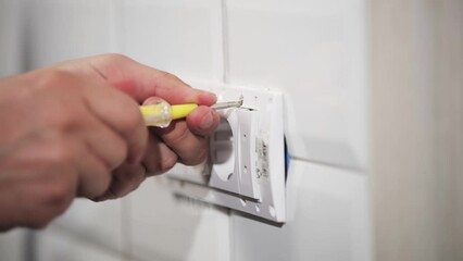 Wall Mural - Electrician repairing and fixing wires in the electrical socket.