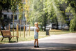 © Linas T - A little boy is standing in the shade of trees in a city park, the child is alone he is afraid of getting lost