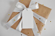 Craft paper gift box on white background. Present with white ribbon and tag mockup