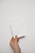 Hand holding blank card mockup. Paper flyer A5 mockup, invitation template isolated on white