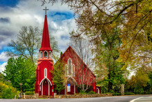 The Red Church Building In The Autumn With Cloudy Sky