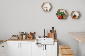 Wall Mural - Counters with kitchen utensils, sink and food near light wall