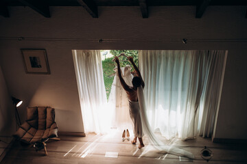 beautiful young bride in a veil with in a white dress in her hands