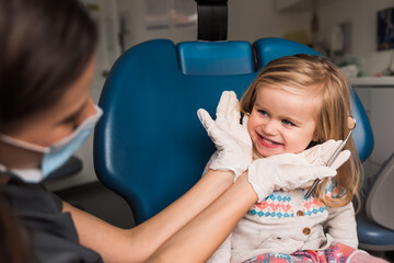 examination, treatment teeth children. medical checkup oral cavity with instruments. dental hands, child in clinic. Cute girl smiling stomatology. Happy kid in dentist chair. concept health, medicine