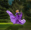 Woman with flowing purple dress floating in air with green trees in background. Magical illustration created for a romantic scene. 