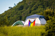 © PhotoSpirit - Camping outdoors with pride LGBT flag on tent and nobody
