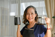© bongkarn - Happy and cheerful asian aged-woman holding a kettle of hot water and hot coffee