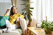 © bongkarn - Happy asian aged woman resting in the living room, sitting on the comfortable sofa