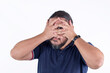 A shy or perverted man hiding his face but peeking with one eye. Isolated on a white background.