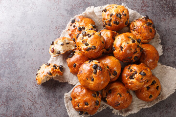 Homemade freshly baked buns with raisins and currants close-up on the table. horizontal top view from above