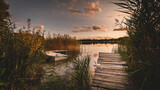 Fototapeta  - Łódka i kładka nad jeziorem o zachodzie słońca