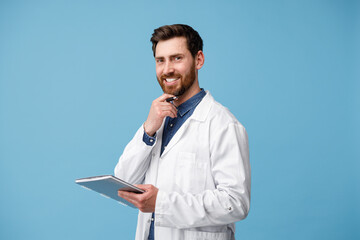 Wall Mural - Portrait of smiling medical specialist in white coat standing with clipboard in hands