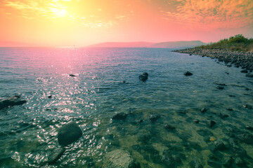 Fototapete - Rocky shore of the Sea of Galilee at sunrise