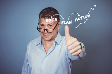 Middle aged business man with blue shirt posing against blue background in the studio