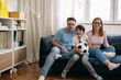 © cherryandbees - caucasian family sitting in living room and watching soccer game on tv