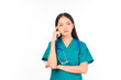 © Png - Video - Photo - Portrait of professional confident young asian female smiling doctor in green scrubs standing thinking to empty space, doctor healthcare and doctors concept.