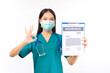 © Png - Video - Photo - Portrait of professional asian female smiling doctor in green scrubs pointing fingers to clipboard health insurance Self-isolation, social distancing.