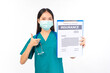 © Png - Video - Photo - Portrait of professional asian female smiling doctor in green scrubs pointing fingers to clipboard health insurance Self-isolation, social distancing.