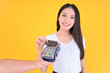 © Png - Video - Photo - Moment of payment, payment with a credit card through terminal money yellow background,Mobile banking, online shopping Payment by card with the payment terminal.