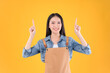 © Png - Video - Photo - pretty asian female smile coffee freelancer own shop ands point up and pose to copy space yellow background.